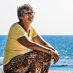 Woman sitting by the sea